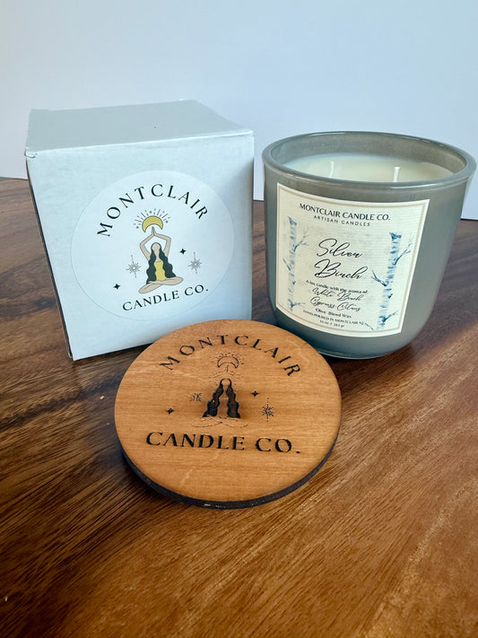 Montclair Candle Co. candle with wooden lid and branded box on a wooden surface
