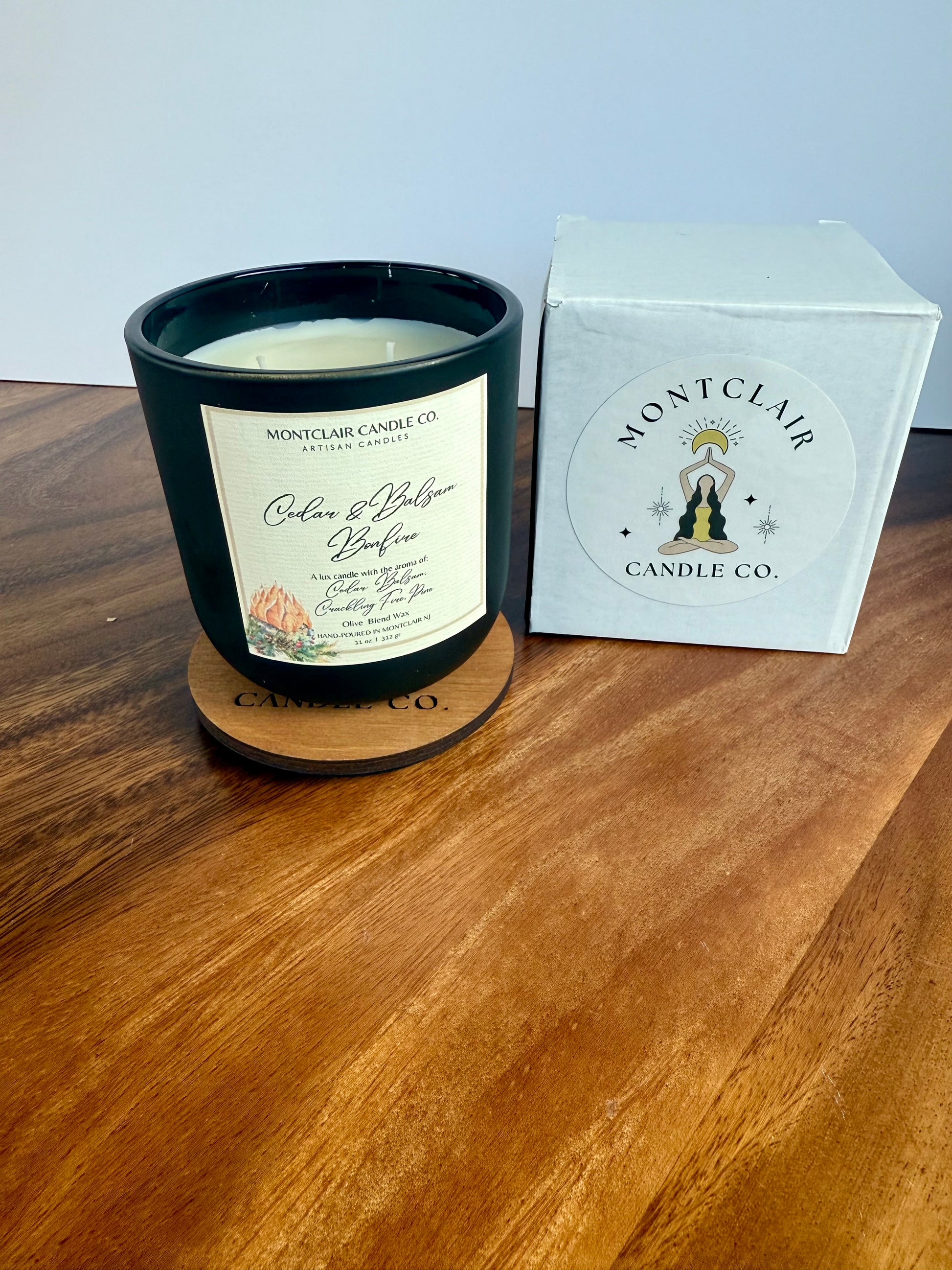 Montclair Candle Co. candle on a wooden surface with packaging in the background