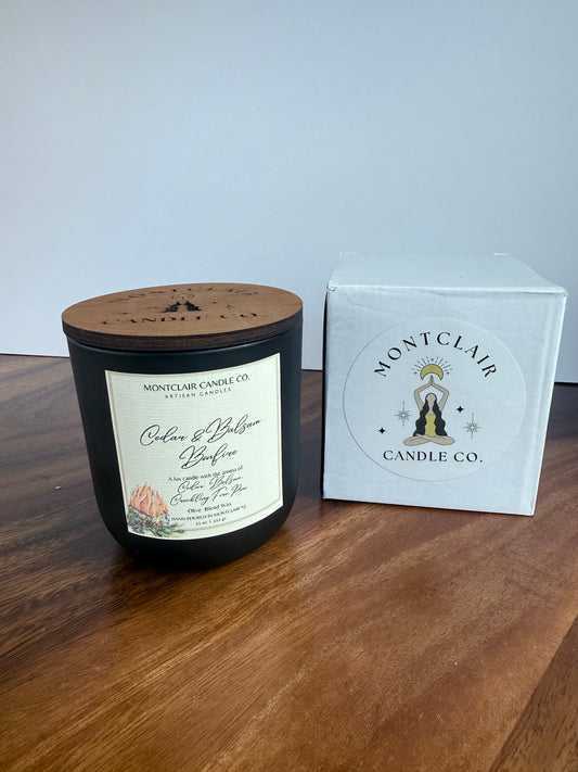 Montclair Candle Co candle and packaging on a wooden surface with a light blue background