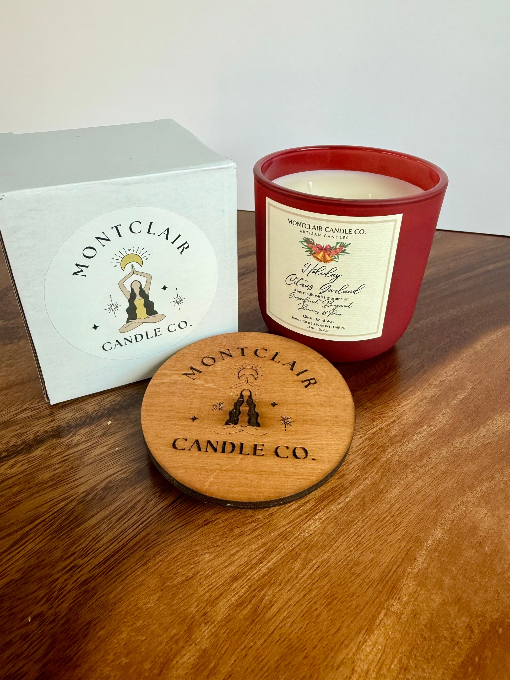 Montclair Candle Co. candle with lid and packaging on a wooden surface