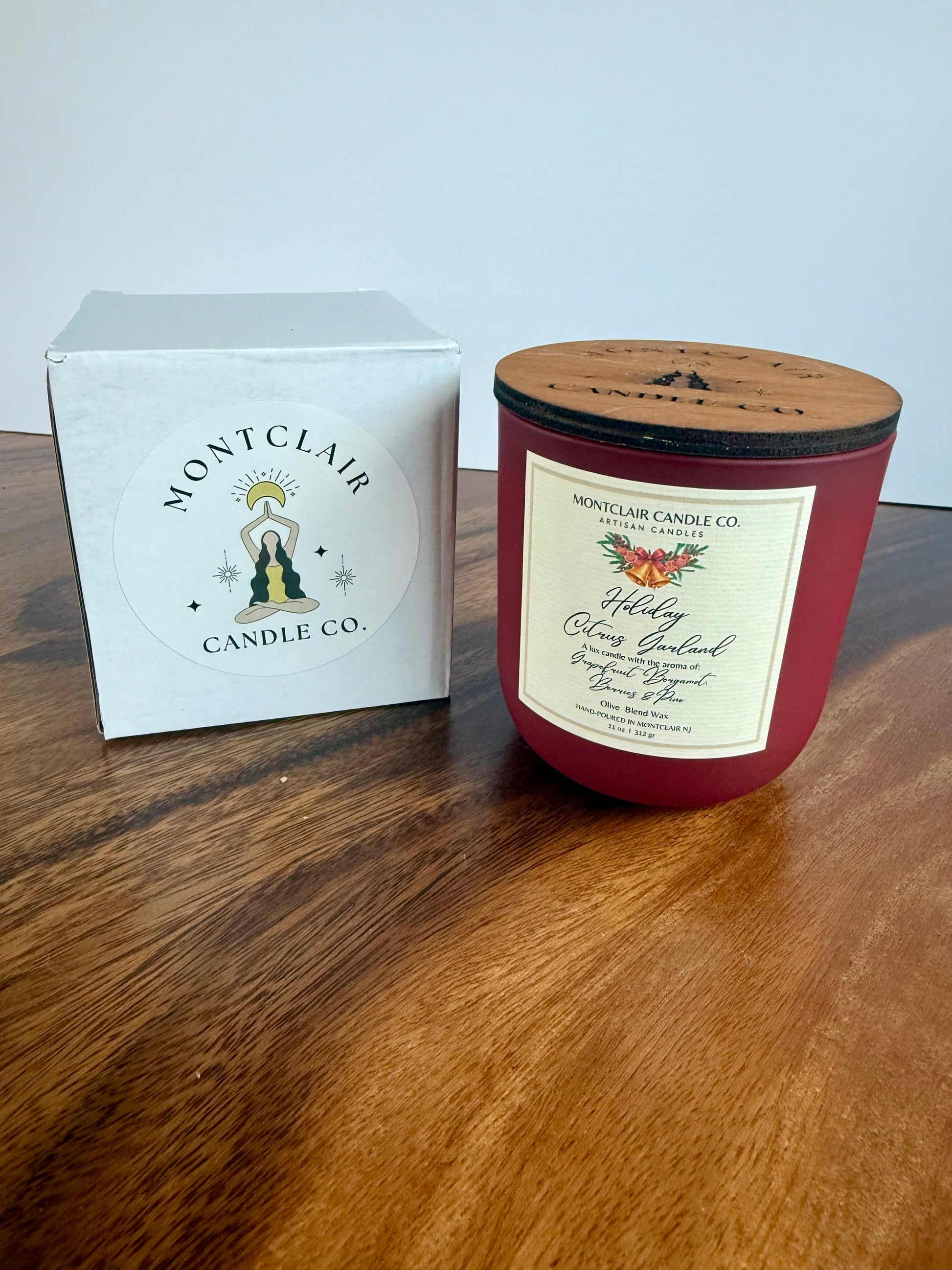 Montclair Candle Co. candle with wooden lid on a wooden surface