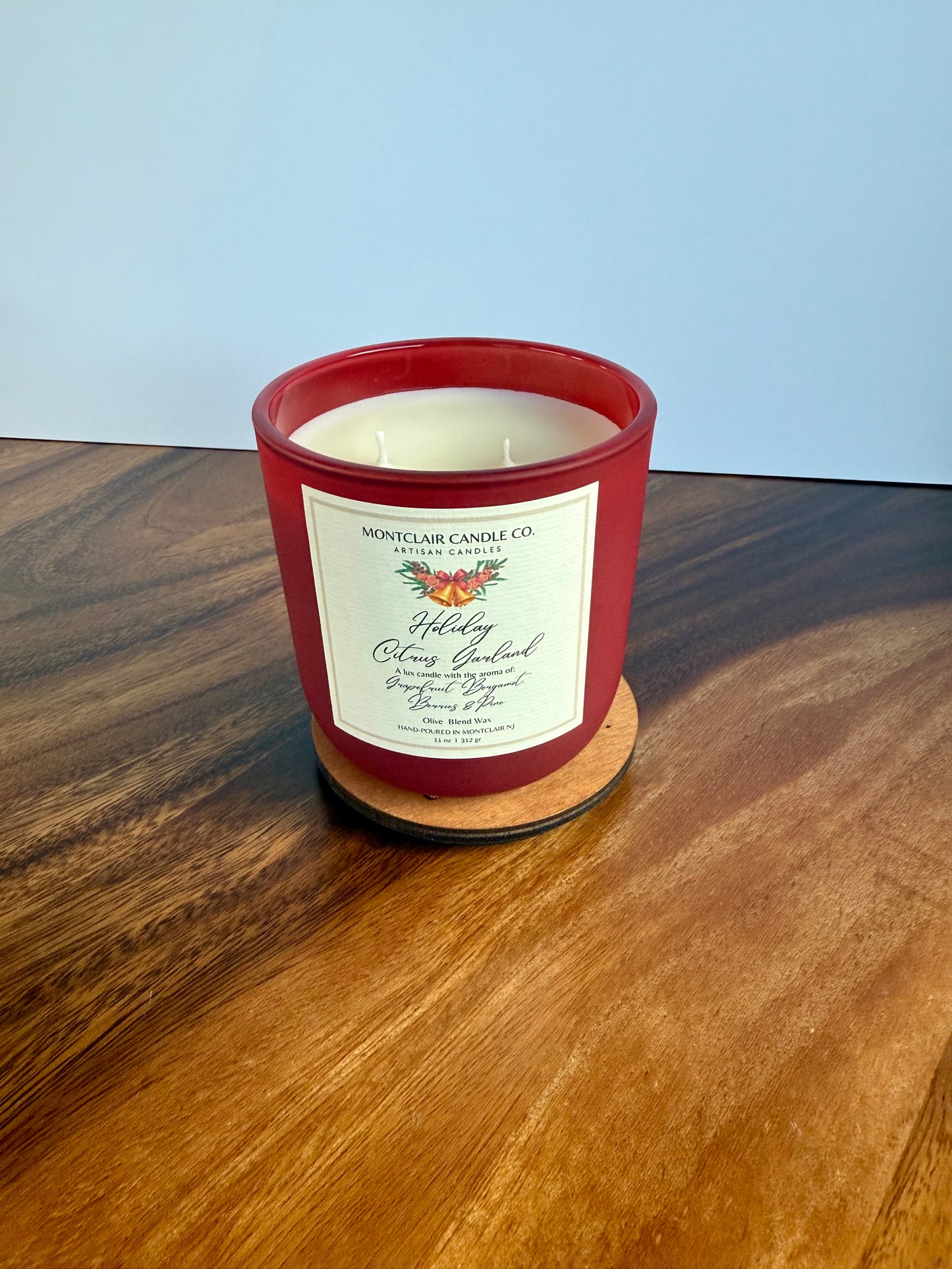 Red candle with a label on a wooden surface