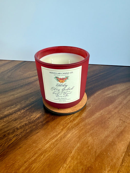 Red candle with a label on a wooden surface