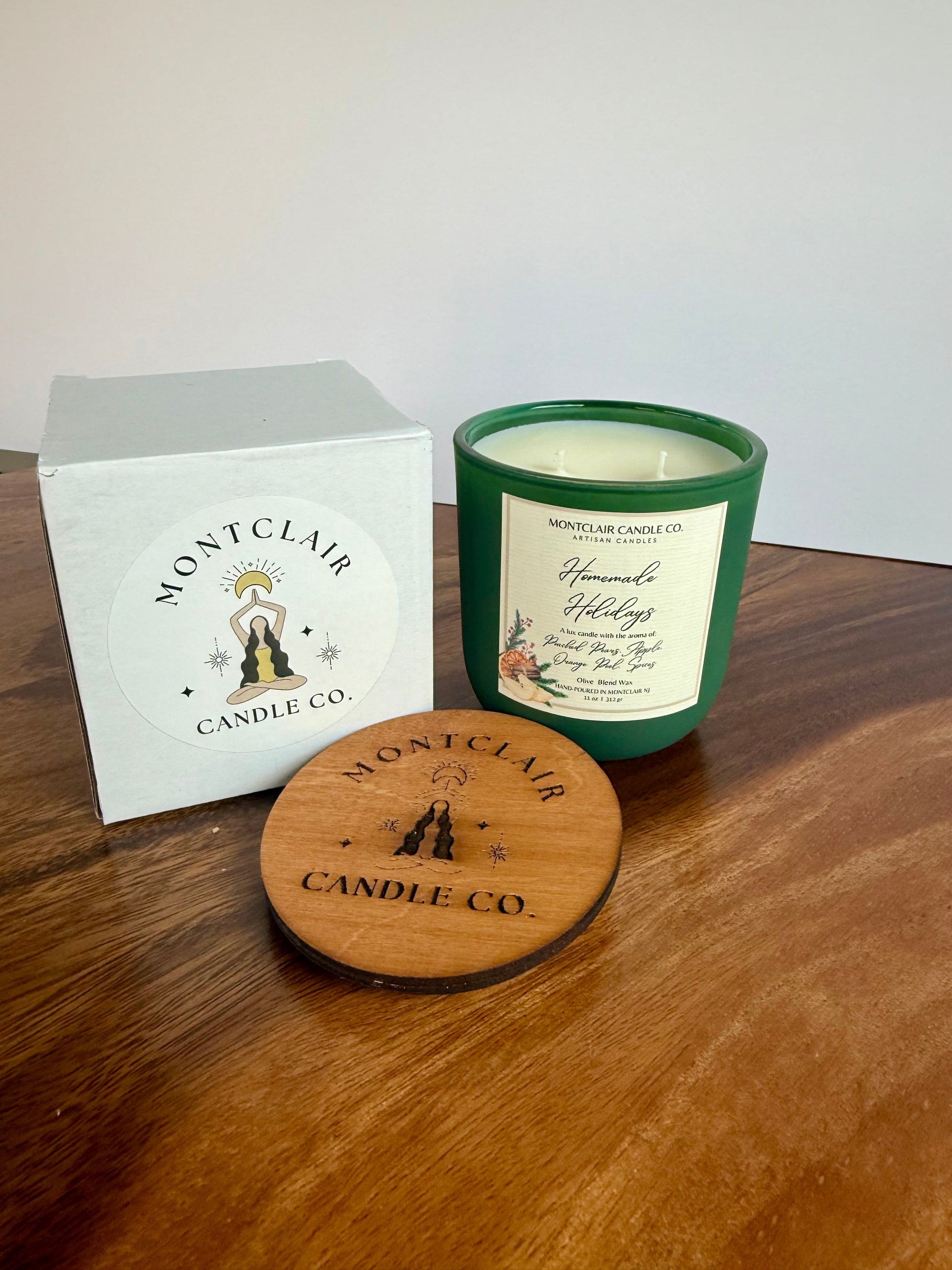 Montclair Candle Co. candle with packaging on a wooden surface