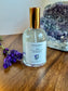 Perfume bottle labeled 'Zen Moments' on a wooden surface with lavender and crystals in the background