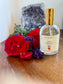 Bottle of 'Sweet Dreams' perfume with red roses and lavender on a wooden surface