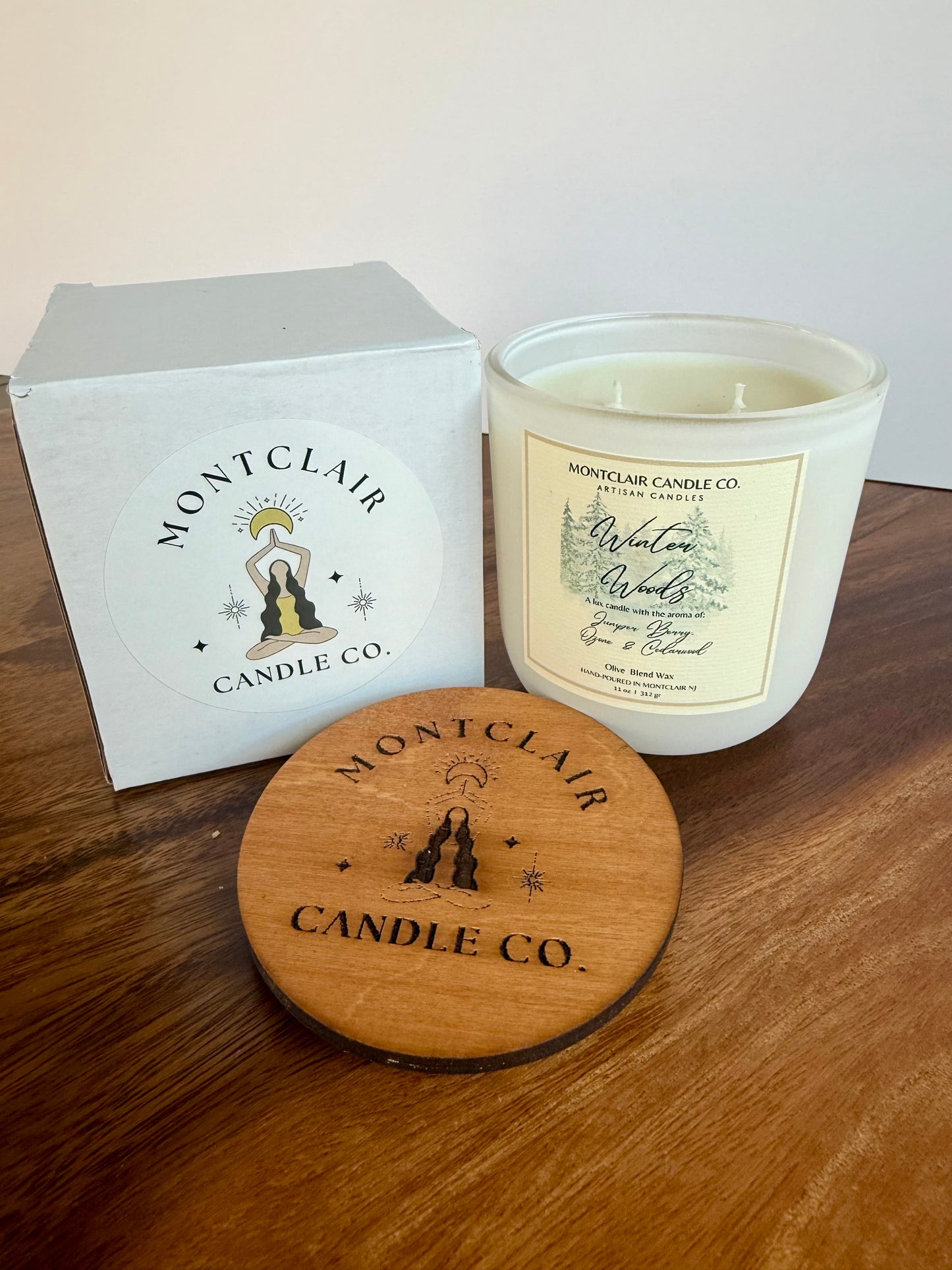 Montclair Candle Co. candle with wooden lid and branded box on a wooden surface